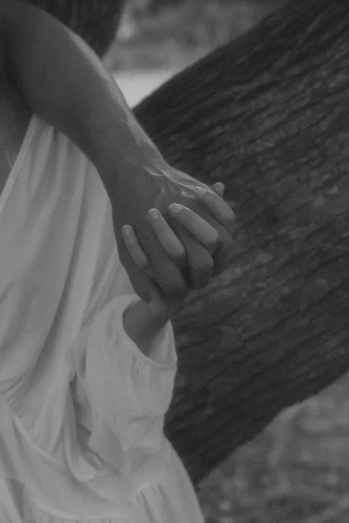Mains entrelacĂ©es sous un arbre, vibration de confiance et dâamour authentique