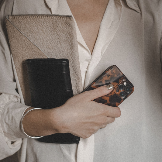 Carnet, téléphone et effets personnels dans les mains d’Alma avant une séance de guidance intuitive à distance.