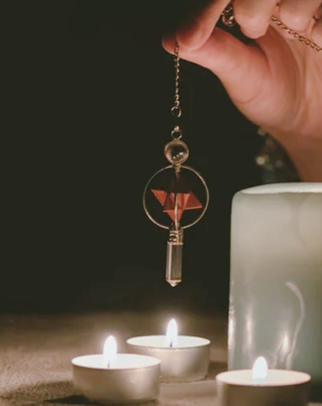 Lecture au pendule dans une ambiance sacrée avec bougies, rituel énergétique spirituel