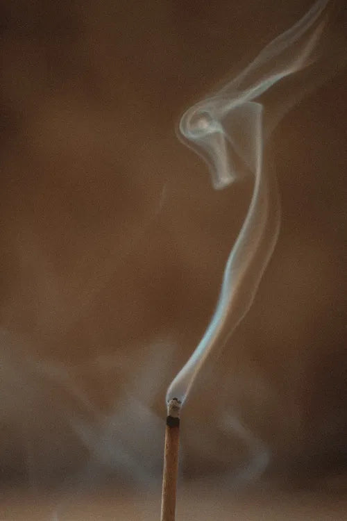 Bâton d’encens en train de brûler, fumée ondulante, représentation du rituel et de la purification dans une guidance médiumnique