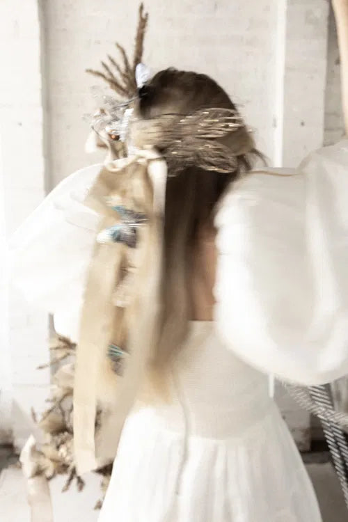 Femme en robe blanche de mariage, évoquant une atmosphère de cérémonie amoureuse.