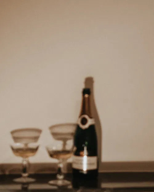 Symbole de prospérité retrouvée après un soin énergétique – bouteille de champagne et deux coupes