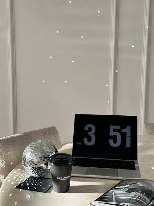 Ambiance douce et moderne autour d’un ordinateur et d’un café noir. L’heure affichée sur l’écran évoque le moment propice pour une guidance intérieure à distance.