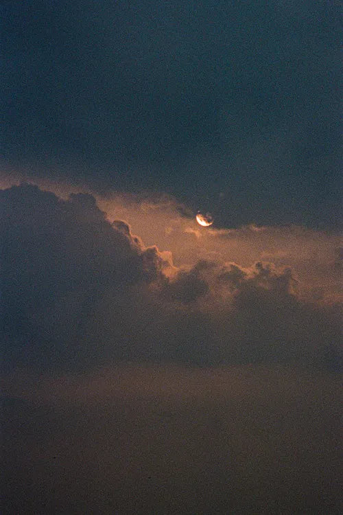 Lune perçant à travers des nuages sombres, à la tombée de la nuit