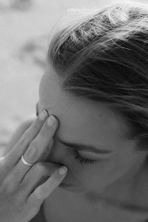 Portrait en noir et blanc d’une femme méditant, concentrée sur son troisième œil