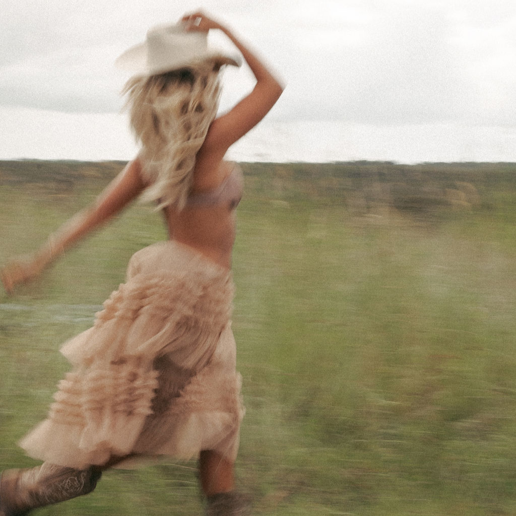 Femme en mouvement dans la nature, libérée après une guidance intuitive, jupe fluide et horizon lumineux