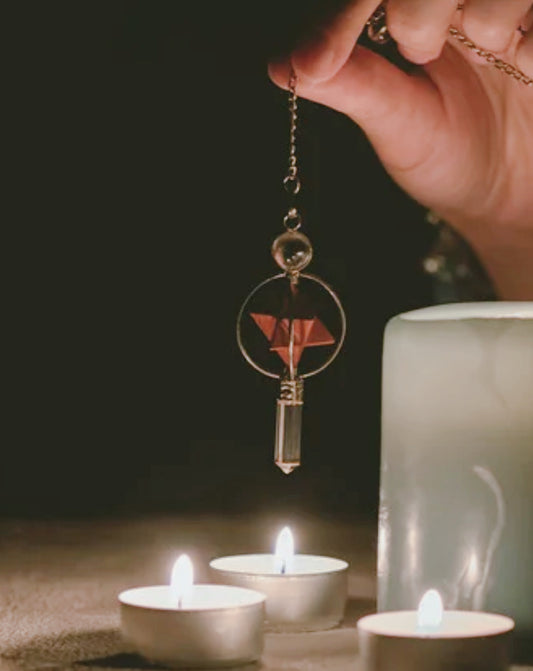 Lecture au pendule dans une ambiance sacrée avec bougies, rituel énergétique spirituel